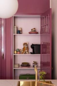a kitchen with a purple cabinet with dishes on it at Luxurious boutique apartment near city centre in Groningen +10 photos