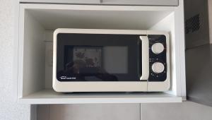 a microwave sitting on a shelf in a kitchen at Frente al Mar con cochera in Miramar