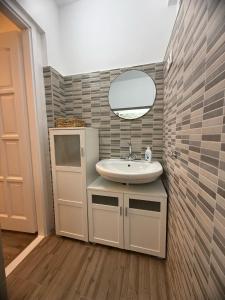a bathroom with a sink and a mirror at Offline Vendégház in Orfű
