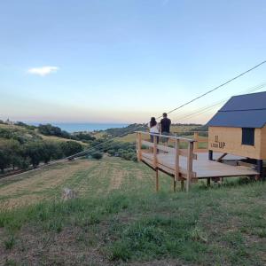 two people standing on a deck looking out over a hill at Potenza Picena StarsBox Orto del Marinaio in Potenza Picena