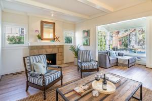 a living room with two chairs and a fireplace at The Sea Captains House & Loft by Paradise Retreats in Santa Barbara