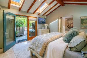a bedroom with a bed and a glass door at Tropical Retreat by Paradise Retreats in Santa Barbara