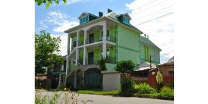 a green and white house on the side of a street at Private house on Trudyashchikhsya in Anapa