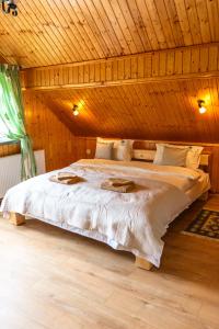 a bedroom with a large bed in a wooden ceiling at Pensiunea Poienita Ursului in Fundata