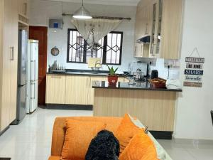 eine Küche mit einer orangefarbenen Couch in einem Zimmer in der Unterkunft Twinhome Inn in Gaborone