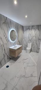 baño de mármol con lavabo y aseo en L&G APARTMENTS BAHíA SUITE, en Alicante 60 fotos más