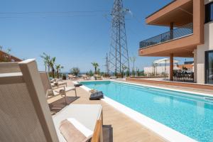 a pool at a resort with chairs and a building at Villa Marko Forever in Makarska