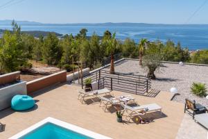 a patio with tables and chairs and a swimming pool at Villa Marko Forever in Makarska