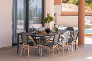 a black dining room table with rattan chairs at Villa Marko Forever in Makarska