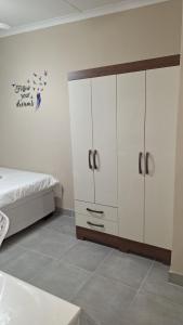 a bedroom with white cabinets and a bed at Serenity in Windhoek