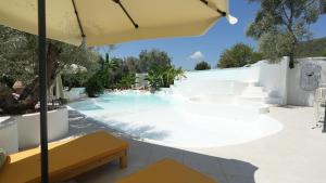 a swimming pool with an umbrella and a yellow bench at Zai Jardin in Fethiye