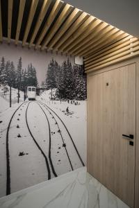 a wall with a mural of a train in the snow at Willa Jodełka in Zakopane