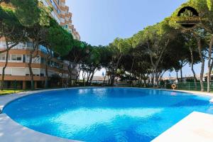 Una gran piscina azul frente a un edificio en Apartamento Calypso, en Sitio de Calahonda
