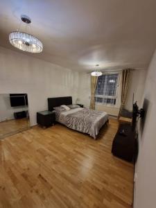 um quarto com uma cama e uma televisão e duas luzes em GX Property em Londres