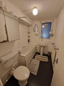 um banheiro com vaso sanitário, pia e banheira em GX Property em Londres