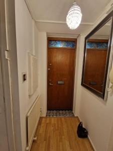 um corredor com uma porta de madeira e um lustre em GX Property em Londres