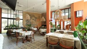 a restaurant with white tables and chairs and windows at Zai Jardin in Fethiye