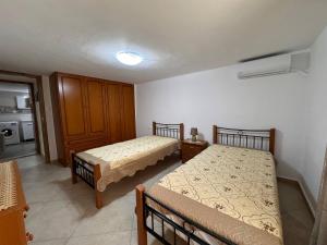 Un dormitorio con dos camas y una cocina. en Eirini's House, en Leonidio
