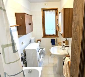 a bathroom with a toilet and a sink at Ciasa Nuvola Apartment in Cibiana