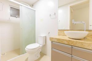 a bathroom with a toilet and a sink at Apto Confortável e Econômico na Praia de Bombas in Bombas +11 photos