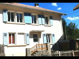 ein weißes Haus mit blauen Fensterläden und einem Zaun in der Unterkunft Gite du Gehan #Vosges #Ski #Nature in Cornimont