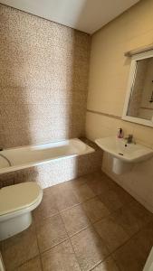 Un baño con inodoro, bañera y lavabo. en Apparemment luxe, en Mahdia 11 fotos más
