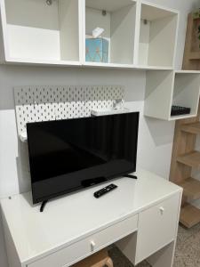 Elle comprend une télévision à écran plat et un bureau blanc. dans l'établissement Crash Boat Coral Villa Aguadilla Big-Affordable, à Aguadilla