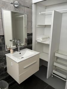 une salle de bain blanche avec un lavabo et un miroir dans l'établissement Crash Boat Coral Villa Aguadilla Big-Affordable, à Aguadilla