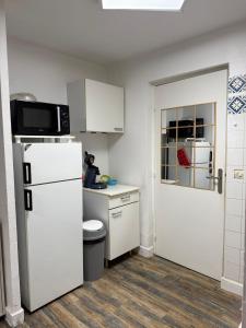 a small kitchen with a refrigerator and a microwave at Villa Massada - déconnexion entre pins & mer in La Seyne-sur-Mer