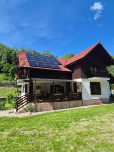 a house with solar panels on the roof at Cabana Minand in Râu de Mori
