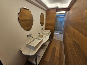 een badkamer met twee wastafels en twee spiegels aan de muur bij Residence L Heritage Tennyson in Mexico-Stad +12 foto's
