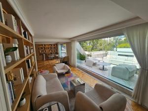 een woonkamer met meubilair en een groot raam bij Residence L Heritage Tennyson in Mexico-Stad