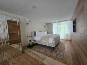 een slaapkamer met een groot bed en een glazen deur bij Residence L Heritage Tennyson in Mexico-Stad