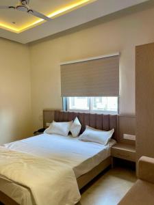 a bedroom with a large bed with a window at HOTEL HERITAGE Inn in Indore
