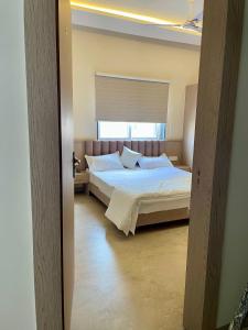 a bedroom with a white bed with a window at HOTEL HERITAGE Inn in Indore +6 photos