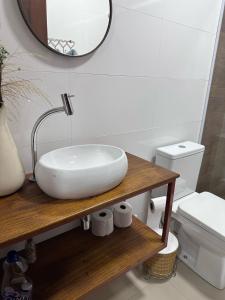 a bathroom with a white sink and a toilet at suite premium em Ilhabela in Ilhabela