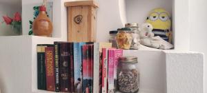 a shelf with books and other items on it at La bouganville Apartments in Cala Gonone