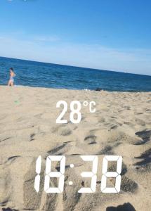 a woman walking on a beach with a written in the sand at À mi-chemin in Claira