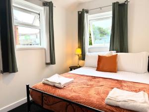 a bedroom with a bed with two windows at Entire 5 Bed New Home - Southampton Centre - 4BDRM in Southampton