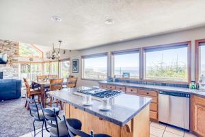 a kitchen with a table and chairs and windows at SeaCret Hideaway in Lincoln City