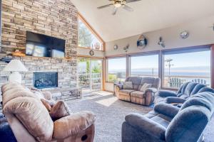 a living room with couches and a stone fireplace at SeaCret Hideaway in Lincoln City