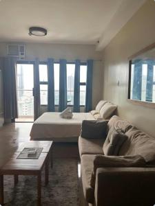 a living room with a bed and a couch at bayviewmansion malate in Manila
