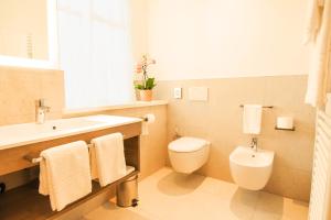 a bathroom with a white toilet and a sink at Das Alte Rathaus in Egna