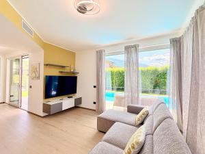 a living room with a couch and a large window at Villa Lake Luxury in Colico