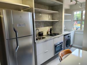 eine Küche mit einem Edelstahlkühlschrank und einer Spüle in der Unterkunft Ape 20A in Sumaré