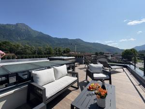 a balcony with a couch and a table and chairs at Villa Lake Luxury in Colico