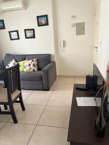 una sala de estar con un sofá y una mesa en Departamento en Mendoza confortable y tranquilo, en Godoy Cruz