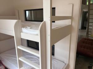 two white bunk beds in a room with a bed at Charmante dépendance in Étriché