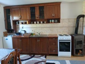 a kitchen with wooden cabinets and a white stove top oven at Apartment Luka in Žabljak