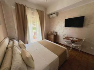 a bedroom with a bed and a table and a television at CASA DEL SOLE Accomodation in Tropea